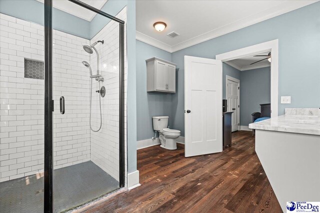 full bath featuring crown molding, toilet, a shower stall, and wood finished floors