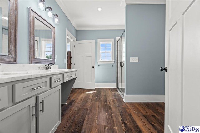 bathroom with crown molding, a stall shower, wood finished floors, and vanity