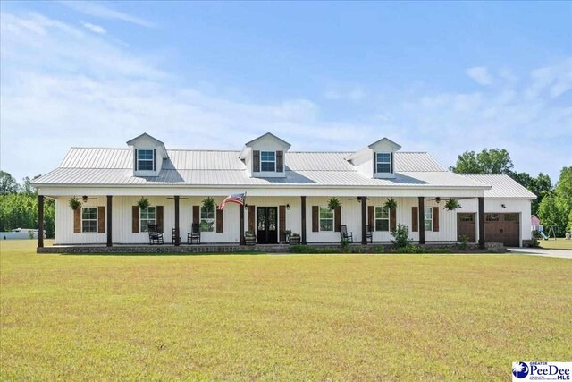 modern farmhouse style home featuring a garage, covered porch, metal roof, and a front yard