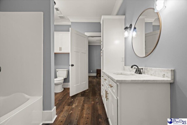 full bathroom featuring crown molding, vanity, a bathing tub, toilet, and wood finished floors