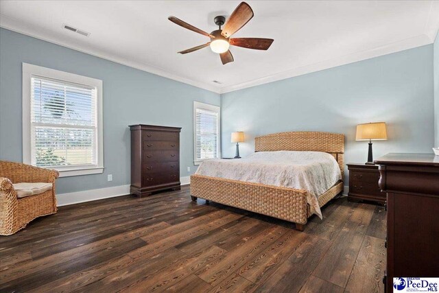 bedroom with ornamental molding, visible vents, multiple windows, and wood finished floors