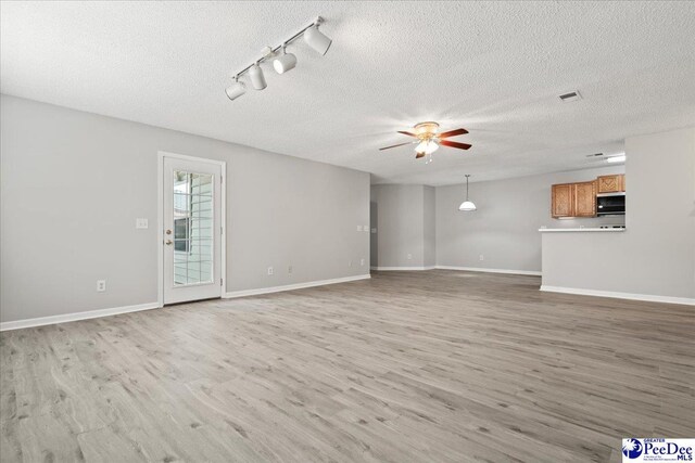 2125-D Sanderling Dr, Florence, SC 29505 - unfurnished living room with rail lighting, light wood-type flooring, ceiling fan, and a textured ceiling