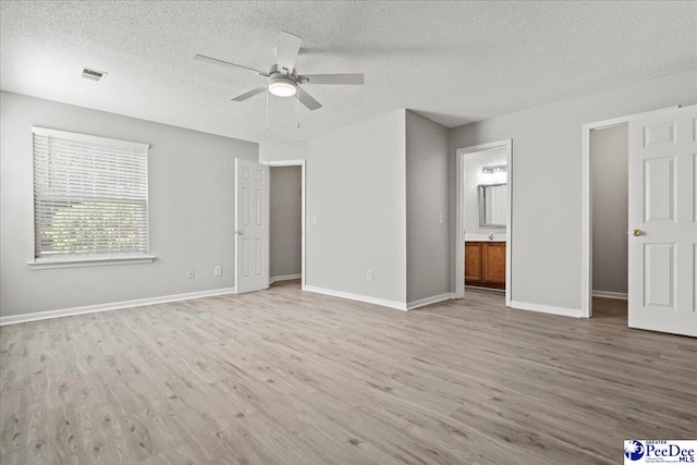 2125-D Sanderling Dr, Florence, SC 29505 - unfurnished bedroom featuring ensuite bath, a textured ceiling, baseboards, and wood finished floors