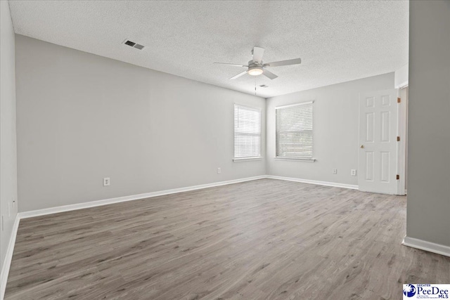 2125-D Sanderling Dr, Florence, SC 29505 - spare room with a textured ceiling, baseboards, ceiling fan, visible vents, and wood finished floors