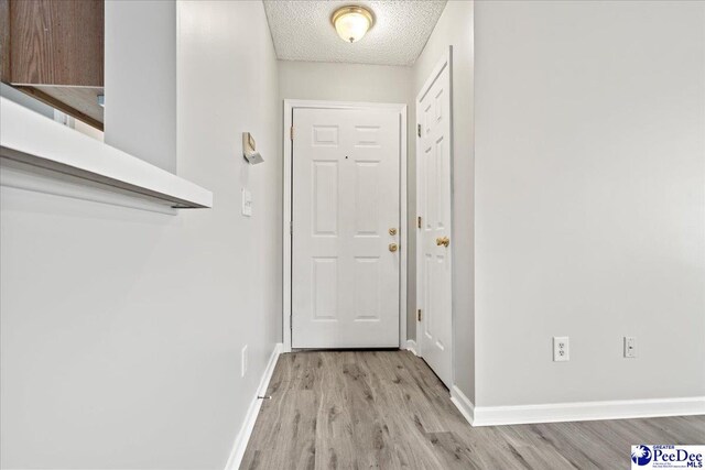 2125-D Sanderling Dr, Florence, SC 29505 - doorway to outside featuring a textured ceiling, baseboards, and light wood-type flooring