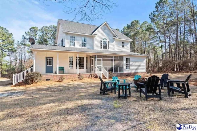 rear view of property with crawl space, an outdoor fire pit, and a sunroom