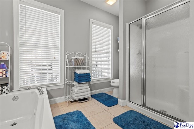 bathroom featuring a garden tub, baseboards, a shower stall, tile patterned floors, and toilet