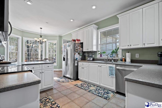 kitchen with stainless steel appliances, ornamental molding, and white cabinetry