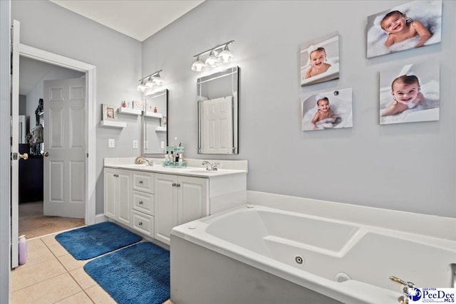 full bath with tile patterned flooring, double vanity, a jetted tub, and a sink