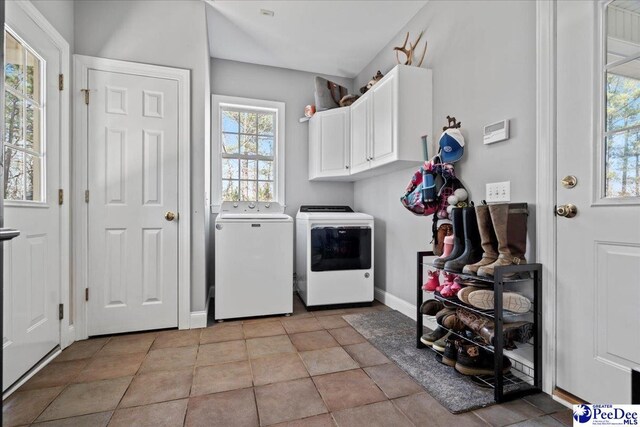 laundry room featuring washer and clothes dryer, cabinet space, and baseboards