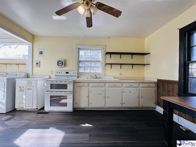 kitchen with range with two ovens, dark hardwood / wood-style floors, white cabinets, and washer and clothes dryer