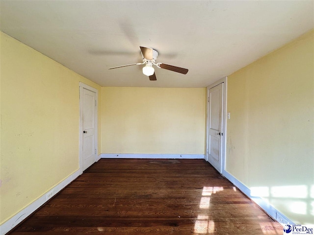 spare room with ceiling fan and dark hardwood / wood-style flooring