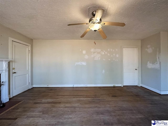 empty room with ceiling fan, dark hardwood / wood-style floors, and a textured ceiling