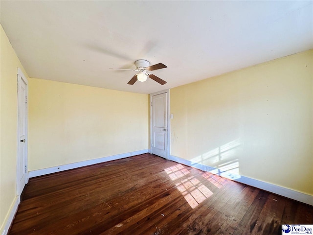 spare room with dark hardwood / wood-style floors and ceiling fan