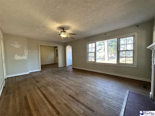 empty room with dark wood-type flooring, a textured ceiling, and ceiling fan