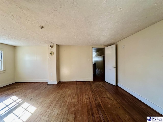 unfurnished room with hardwood / wood-style flooring and a textured ceiling