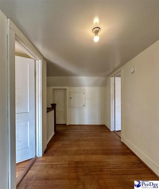 hallway featuring hardwood / wood-style flooring and vaulted ceiling