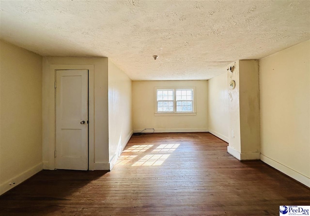 interior space with dark wood-type flooring and a textured ceiling