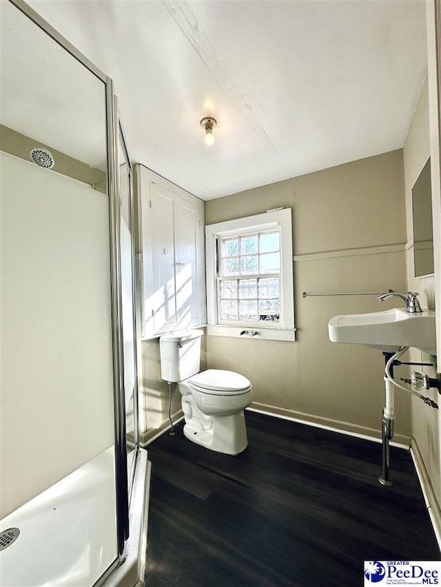 bathroom featuring sink, toilet, an enclosed shower, and hardwood / wood-style floors