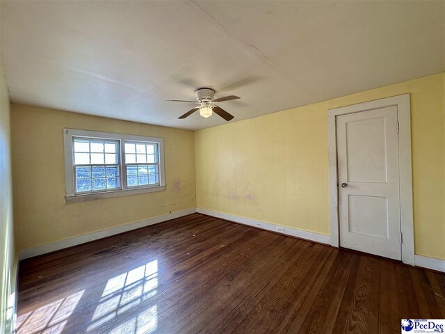 empty room with dark wood-type flooring and ceiling fan