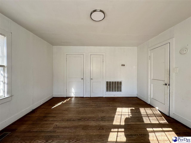 spare room with dark wood-type flooring