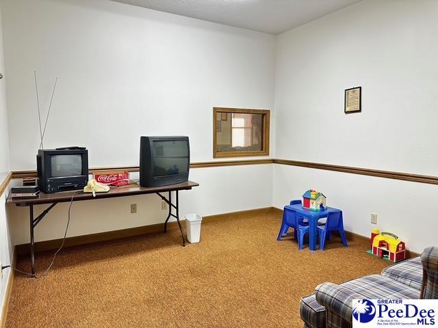 carpeted home office featuring baseboards