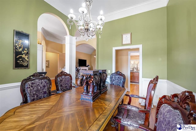 953 Rice Planters Ln, Florence, SC 29501 - dining space featuring arched walkways, decorative columns, ornamental molding, a chandelier, and wainscoting
