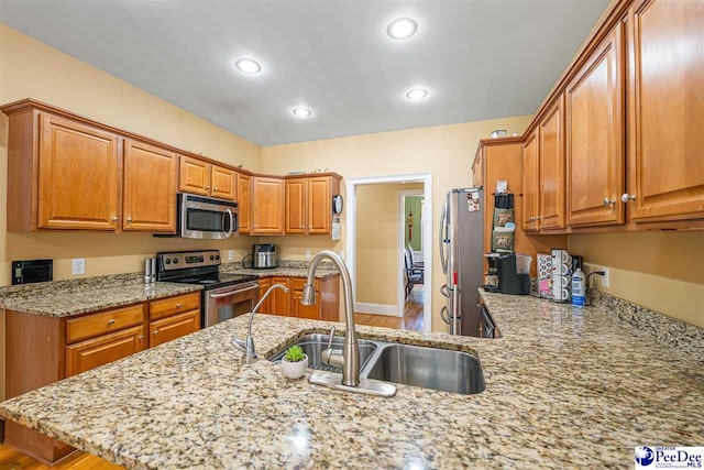 953 Rice Planters Ln, Florence, SC 29501 - kitchen with appliances with stainless steel finishes, a sink, light stone countertops, brown cabinets, and recessed lighting