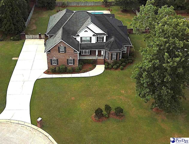 view of front facade featuring a porch, concrete driveway, and a front lawn