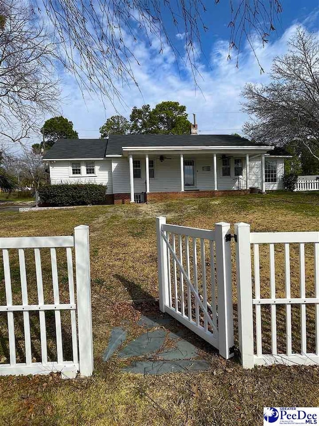 view of front of property with a fenced front yard, a front lawn, and a porch