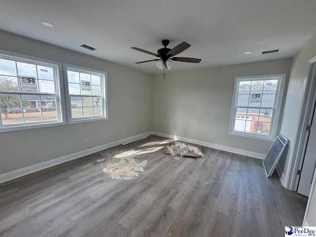 empty room featuring recessed lighting, visible vents, a ceiling fan, baseboards, and dark wood-style flooring