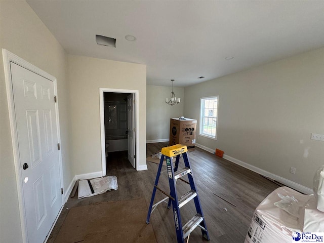 interior space with baseboards, dark wood-style floors, and an inviting chandelier