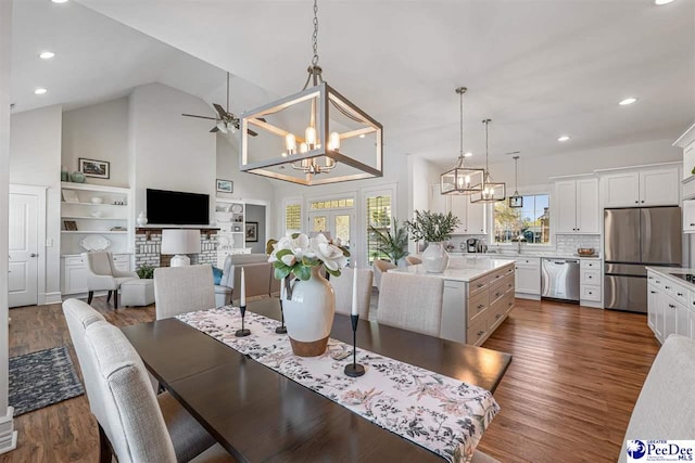dining room featuring dark wood-style floors, ceiling fan with notable chandelier, high vaulted ceiling, and recessed lighting