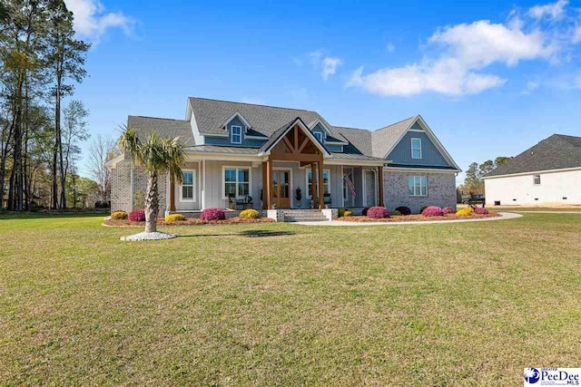 view of front facade with a front yard, covered porch, a standing seam roof, board and batten siding, and metal roof