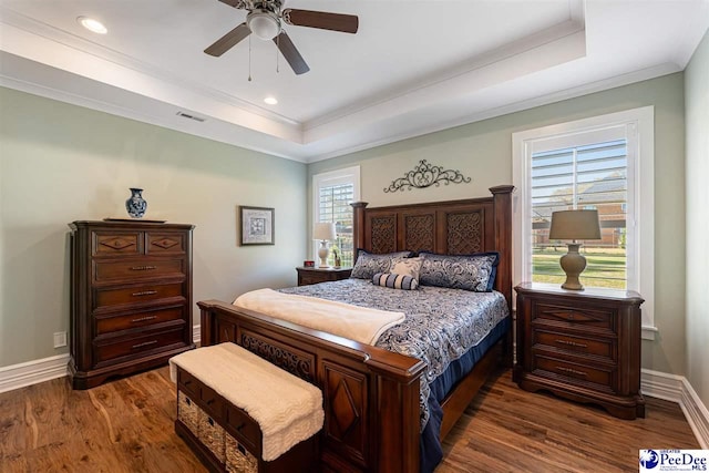 bedroom with a raised ceiling, dark wood-type flooring, and visible vents