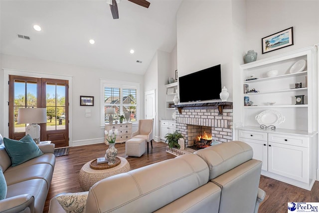 living area with dark wood finished floors, visible vents, ceiling fan, and a brick fireplace