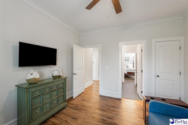 bedroom featuring ornamental molding, baseboards, ceiling fan, and wood finished floors