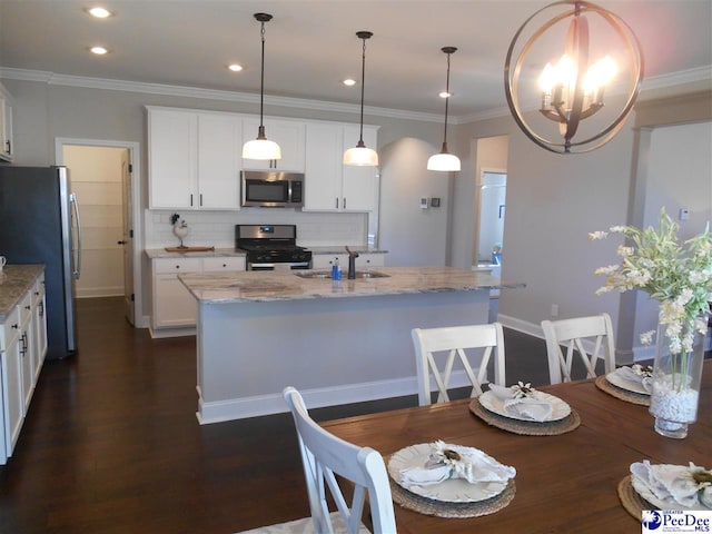 1081 Wessex Dr, Florence, SC 29501 - kitchen featuring an island with sink, a sink, decorative backsplash, stainless steel appliances, and crown molding