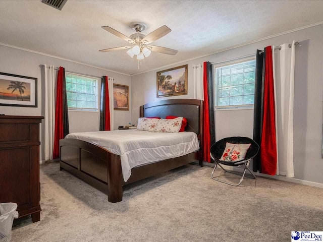 bedroom featuring ceiling fan, ornamental molding, light carpet, and multiple windows