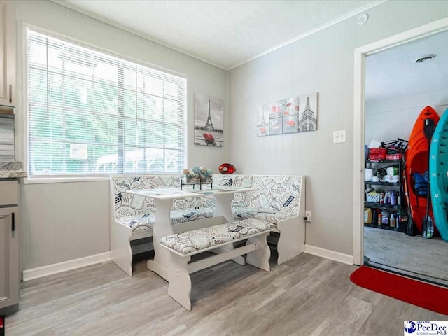 dining room with breakfast area, crown molding, and light hardwood / wood-style floors