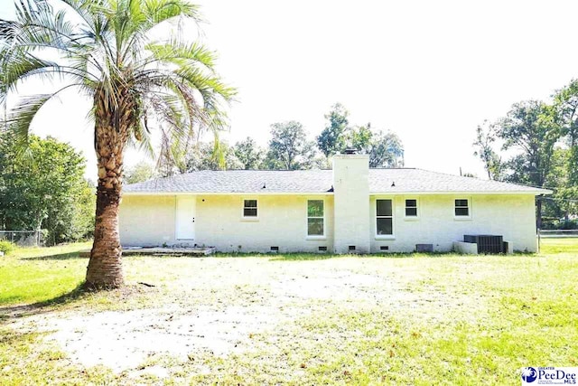 back of house with a lawn and central air condition unit