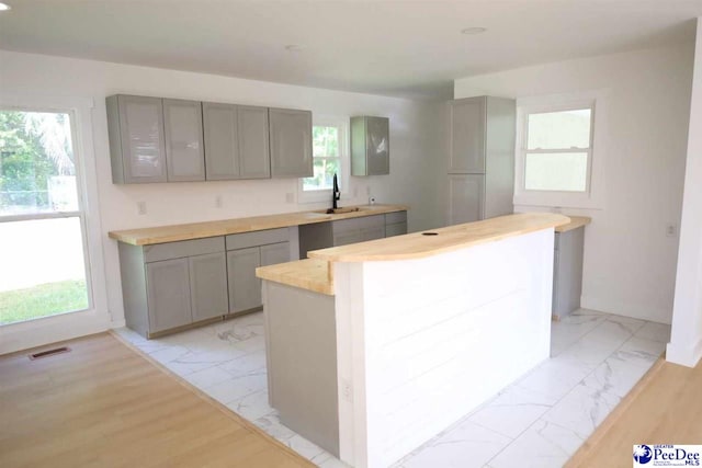 kitchen featuring a kitchen island, sink, and gray cabinetry