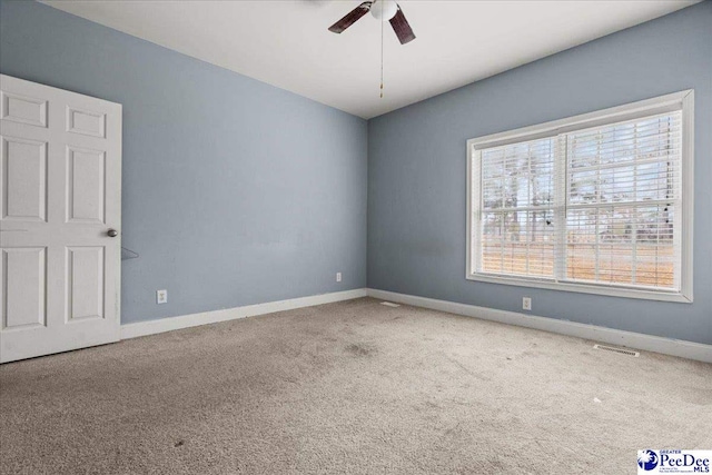 carpeted spare room featuring ceiling fan