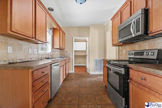 kitchen with sink, decorative backsplash, and appliances with stainless steel finishes