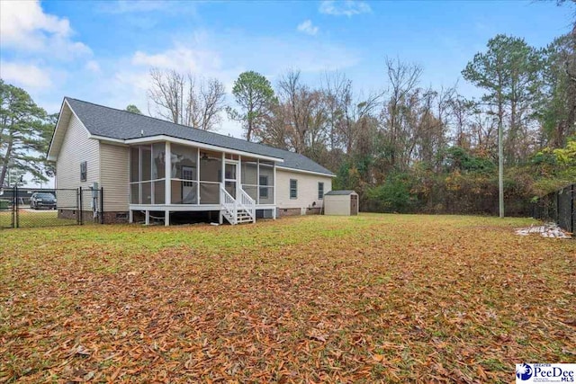 rear view of property with a yard, a storage unit, and a sunroom