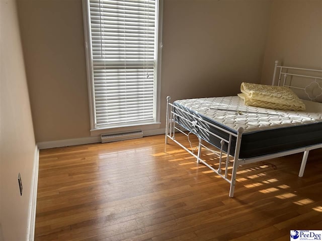 bedroom with hardwood / wood-style flooring, visible vents, and baseboards