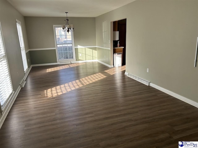 unfurnished dining area featuring a chandelier, dark wood-type flooring, visible vents, and baseboards