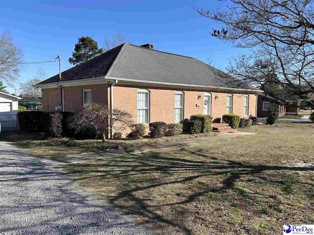 view of property exterior with roof with shingles and brick siding