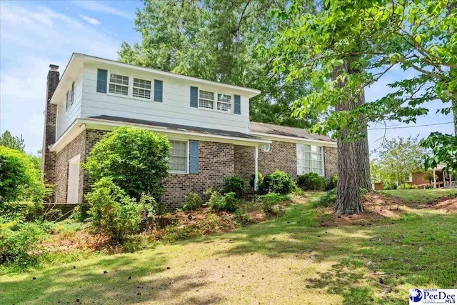 231 Timberlake Dr, Florence, SC 29501 - view of front of house featuring brick siding, a chimney, and a front yard