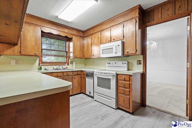 231 Timberlake Dr, Florence, SC 29501 - kitchen featuring white appliances, a textured ceiling, brown cabinetry, light countertops, and crown molding